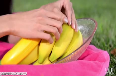 Миленькая азиатка старательно трахает себя в киску бананом